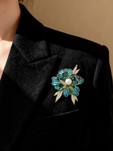Detailed close-up of a vintage enamel peony brooch with blue-green petals and pearl