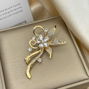 Broche fleur dorée de luxe avec cristaux et pompons sur une boîte à bijoux élégante