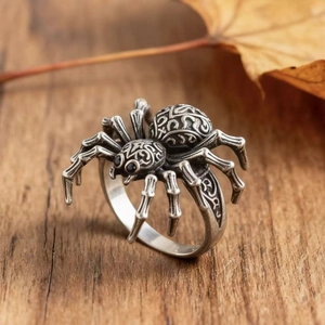 Gothic spider ring in antique silver finish with detailed floral carvings on wooden base