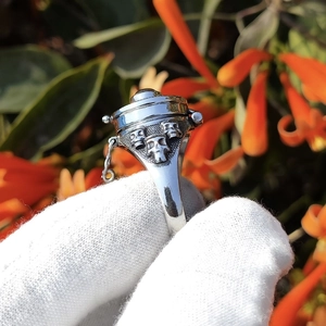 Dettaglio anello teschio argento con catena e coperchio apribile in stile punk