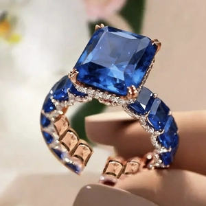 Anillo de lujo en oro rosa con zafiro azul rectangular y detalles de diamantes