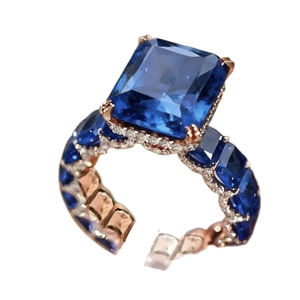 Elegante anillo de oro rosa con zafiro azul rectangular y pavé de pequeñas gemas