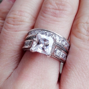 Macro shot of silver bridal ring set with princess cut zircon and pave diamond band