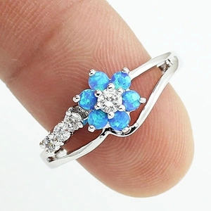 Macro view of blue opal flower ring featuring a sparkling central zircon and silver band