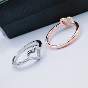 Detailsicht minimalistischer hohler Herzringe in Silber und Roségold-Beschichtung