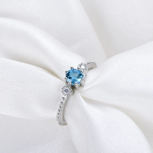 925 silver plated blue gemstone ring with gold accents and beaded texture on white silk