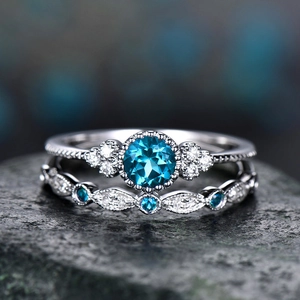 Macro-detail van de zilveren ringenset met ronde blauwe edelsteen en schitterende diamanten