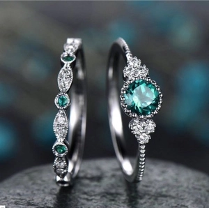 Elegante zilveren ring met smaragd en zirkoon op donkere stenen achtergrond