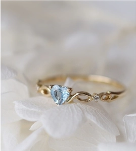 Anello di fidanzamento con topazio blu a cuore e fascia intrecciata in oro e diamanti