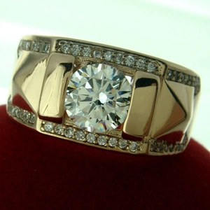 Vue macro d'une bague de couple dorée avec un grand zircon et pavage de diamants