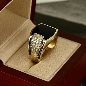 Macro detail of men's gold signet ring with rectangle black stone and micro pavé stones