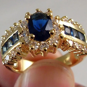 Anello in oro con zaffiro blu ovale e alone di zirconi per uno stile di gioielleria di lusso