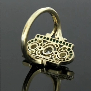 Luxurious vintage gold ring with emerald gemstones and intricate hollow carving detail