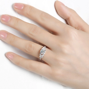 Elegant silver bow-tie ring with round brilliant center stone on a model's hand