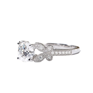 Bowknot engagement ring with round center stone and pave diamonds in silver finish