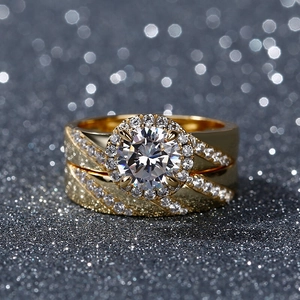 Vue macro de parure de bagues dorées avec pierre halo centrale et détails pavés de zircons