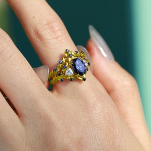 Elegante anello d'oro con un grande zaffiro blu ovale e scintillanti diamanti