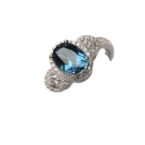 Anello vintage con gemma blu ovale e diamanti su una montatura in argento lucido