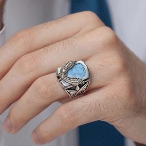 Detailed macro shot of a men's eagle ring with turquoise stone and vintage silver finish
