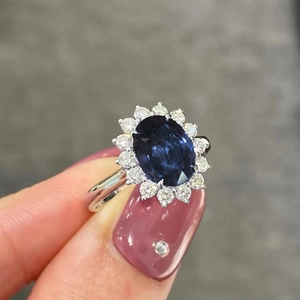 Dettaglio dell'anello classico con zaffiro blu ovale e alone di zirconi bianchi