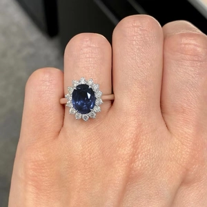 Dettaglio macro di un anello con zaffiro ovale e alone di diamanti scintillanti