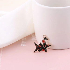 Macro shot of Japanese style black origami crane enamel pendant with red cherry blossom pattern