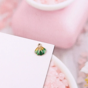 Detalle macro del colgante de concha esmaltado con degradado amarillo y verde para joyas