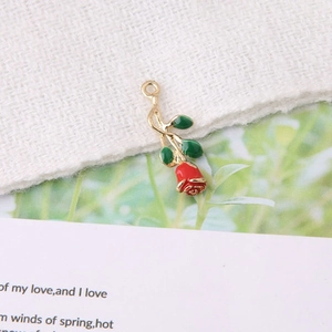 Détail de breloque rose émaillée rouge avec feuille verte pour création de bijoux DIY