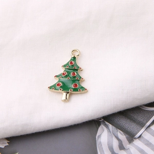 Detailansicht eines grünen Emaille-Weihnachtsbaum-Anhängers mit goldenen Akzenten und Ring