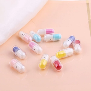 Colorful 3D pill charms with cute faces for DIY jewelry making on a pink background