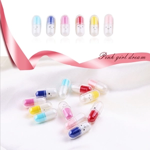 Macro shot of colorful plastic capsule charms with cute expressions on white satin fabric