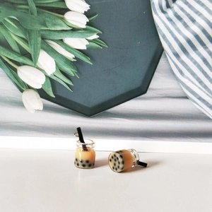 Close-up of miniature bubble tea resin charms with realistic black pearls and metal loops