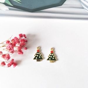 Detail shot of green Christmas tree charms with gold plating for DIY jewelry making