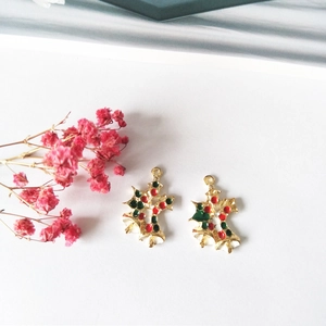 Close-up of DIY Christmas bell charms with green leaves for earring and necklace making