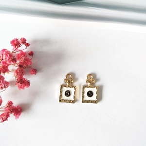 Dettaglio di ciondoli a forma di flacone di profumo dorato con numero 5 per gioielli DIY