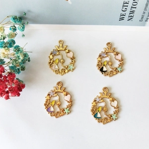 Close-up of four Alice theme DIY alloy pendants with golden frames and floral details