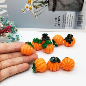 Mini resin pumpkin pendants for DIY Halloween jewelry making with orange and green finish