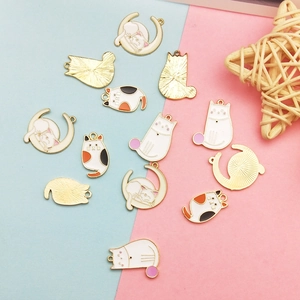 DIY emaille kat en maan hangers voor sieraden op een roze en blauwe pastel achtergrond