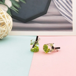 Makroaufnahme von Miniatur-Resin-Kiwi-Getränkebechern mit Metall-Aufhängeringen