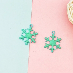 Nahaufnahme von grünen Glitzer-Schneeflocken-Anhängern für DIY-Schmuckherstellung