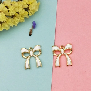 Détail de pendentifs nœuds DIY avec cadre doré et émail blanc pour bijoux