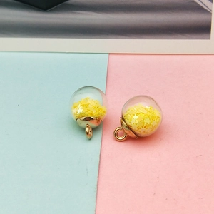 Detail of DIY glass ball pendants with yellow star sequins and golden metal clasp