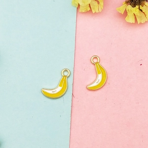 Detailed view of yellow enamel banana charms with golden metal base for DIY jewelry