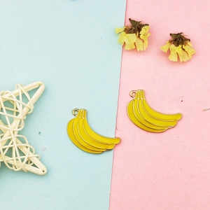 Macro view of banana enamel charms with gold metallic edges for DIY jewelry making