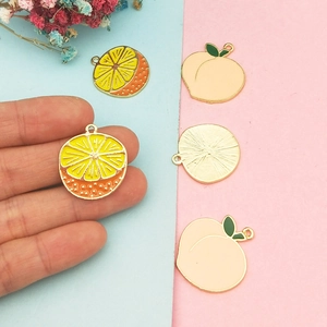 Handmade fruit pendants featuring lemon slices and pink peach designs for DIY jewelry