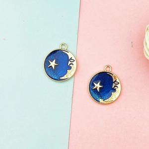 Detail view of round blue enamel charms with gold star and moon patterns for DIY jewelry making