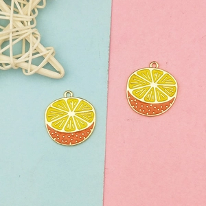 Detail of citrus fruit charms showing yellow and orange enamel and metal hanging loops
