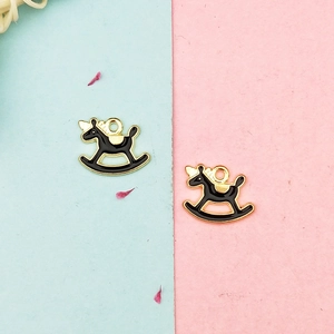 Detail view of two black enamel rocking horse charms with gold edges for DIY jewelry making
