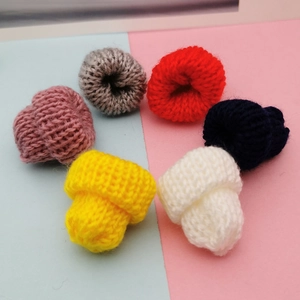Set of 6 mini colorful knitted beanies for DIY crafts and doll accessories on a two-tone background