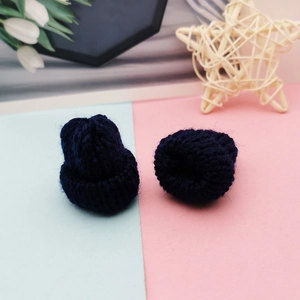 Detail of two navy blue mini knitted hats for DIY crafts and doll accessories